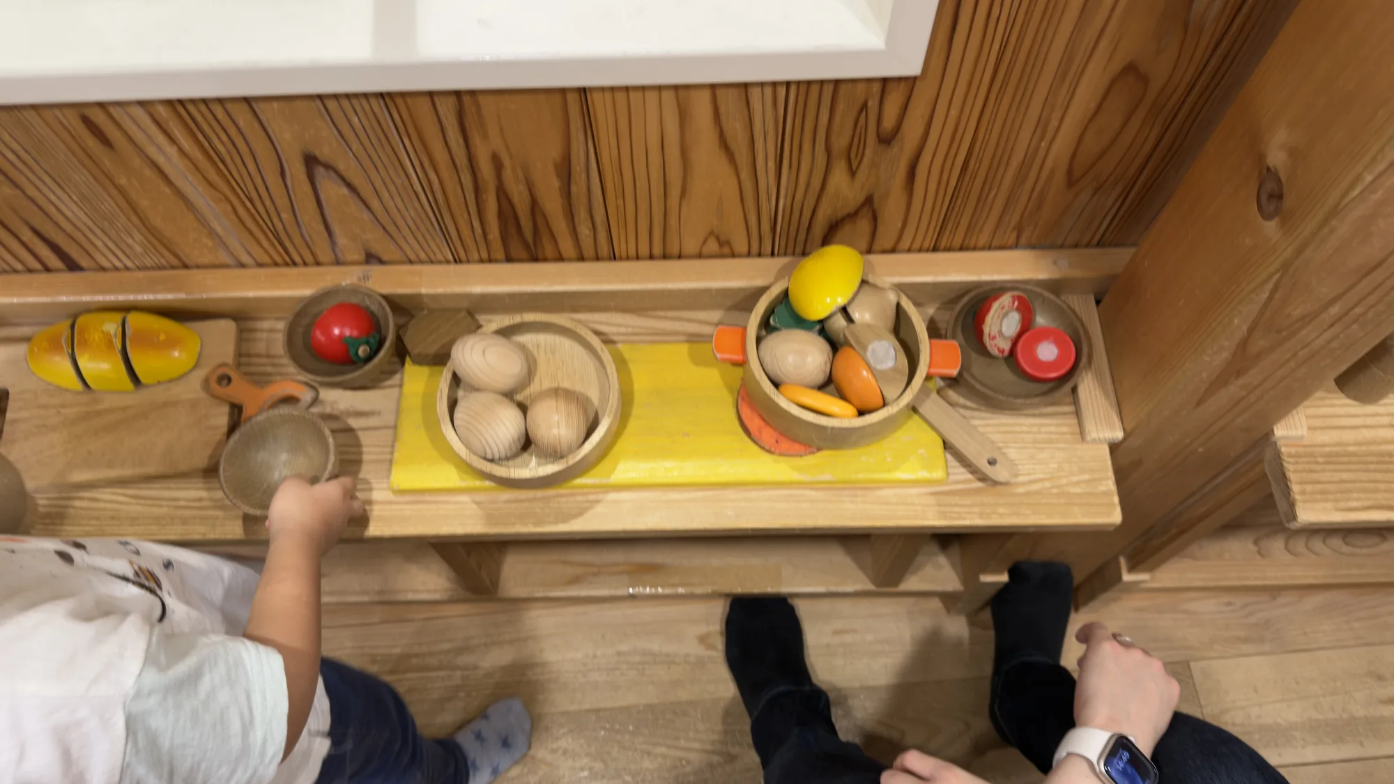 子どもが京王あそびの森HUGHUGの木製おままごと遊具で遊ぶ様子