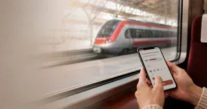 AI生成イメージ：スマートフォンで特急列車の座席予約を確認する場面